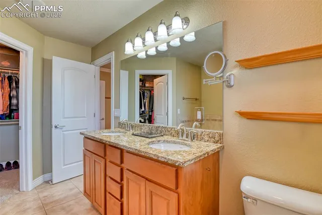 a bathroom with a granite countertop sink a toilet and a mirror