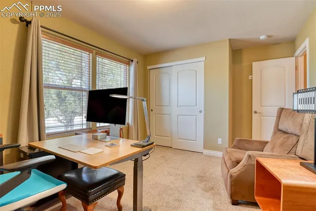 a view of a workspace with furniture and a window