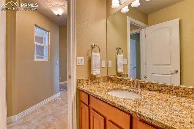 a bathroom with a granite countertop sink and a mirror