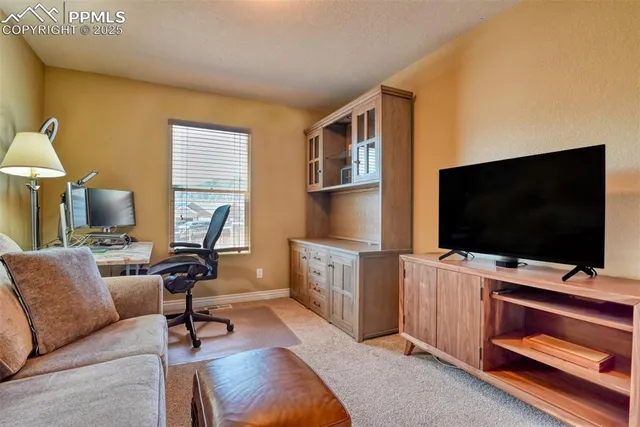 a view of a livingroom with workspace and a window