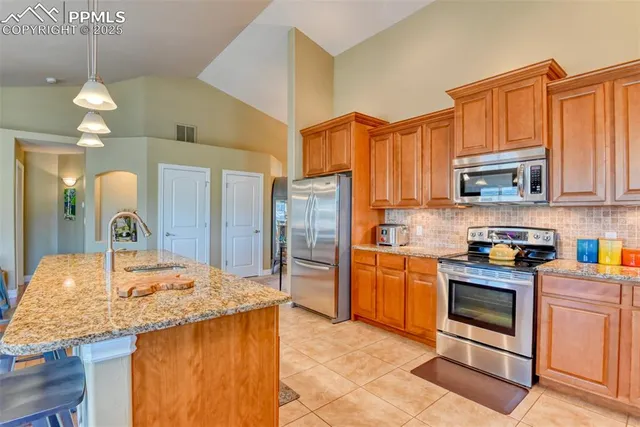 a kitchen with stainless steel appliances granite countertop a stove a sink and a refrigerator