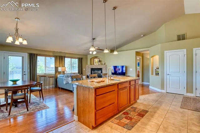 a kitchen view with stainless steel appliances granite countertop a stove oven and a dining table with wooden floor