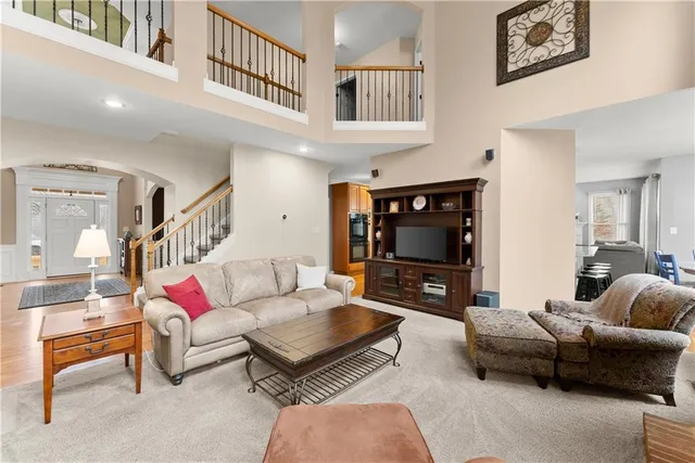 a dining room with stainless steel appliances kitchen island granite countertop a dining table chairs and a refrigerator