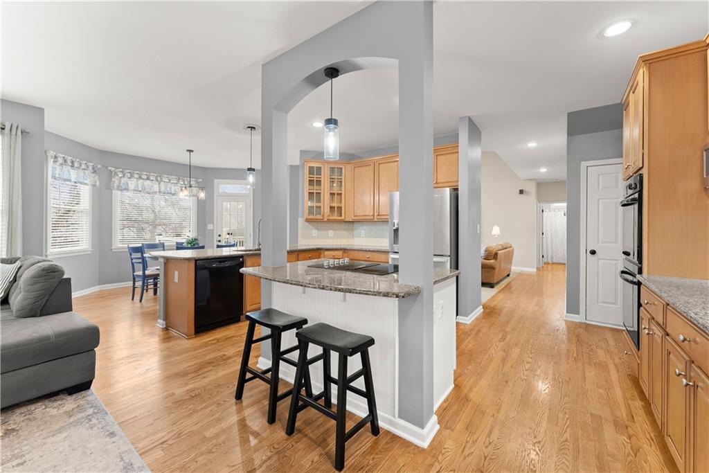1070 Coleridge Way Suwanee, GA 30024 - Photo 16 of 98 a open kitchen with stainless steel appliances granite countertop a stove a sink dishwasher and a refrigerator with wooden floor