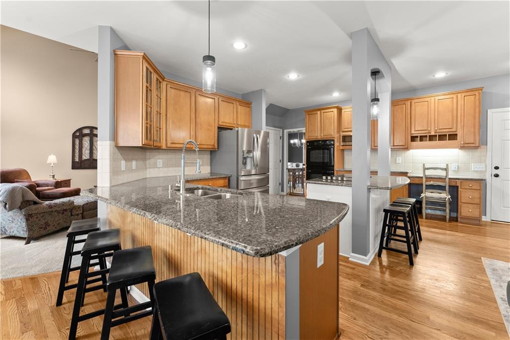 1070 Coleridge Way Suwanee, GA 30024 - Photo 18 of 98 a kitchen with stainless steel appliances granite countertop a table chairs sink and cabinets