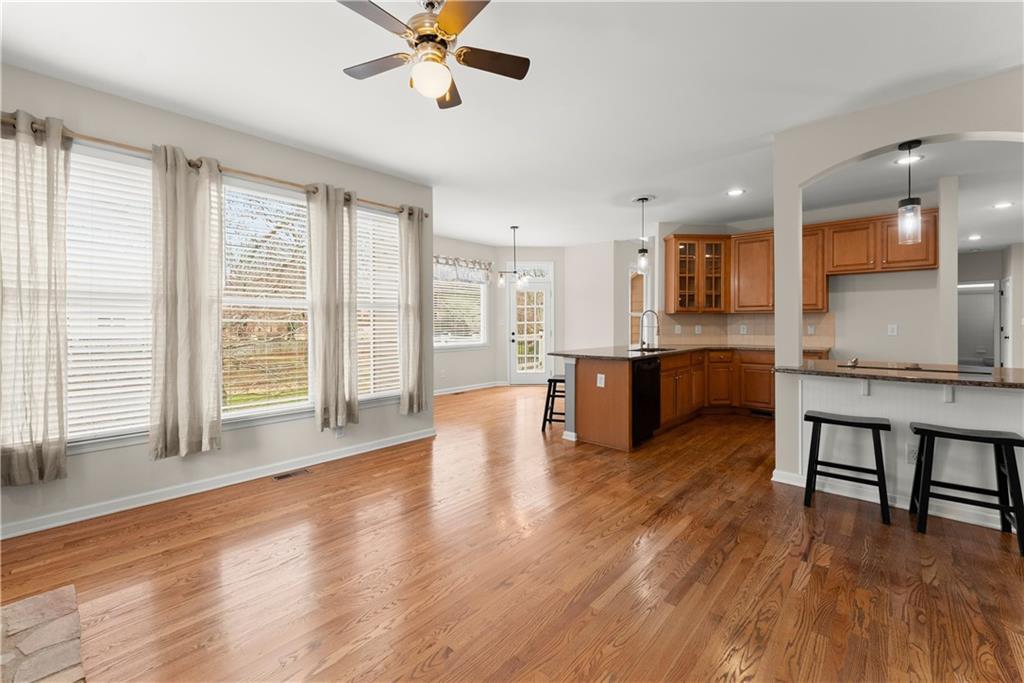 1070 Coleridge Way Suwanee, GA 30024 - Photo 18 of 76 a living room with stainless steel appliances kitchen island granite countertop wooden floors and a large window