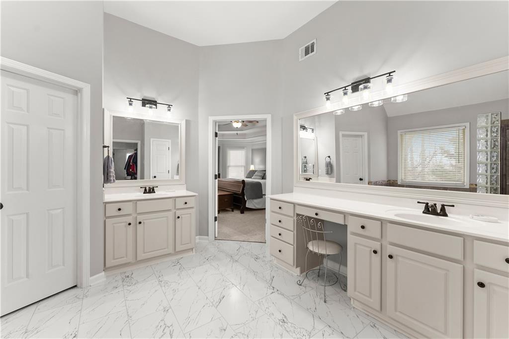 1070 Coleridge Way Suwanee, GA 30024 - Photo 32 of 76 a spacious bathroom with a granite countertop sink mirror and bathtub