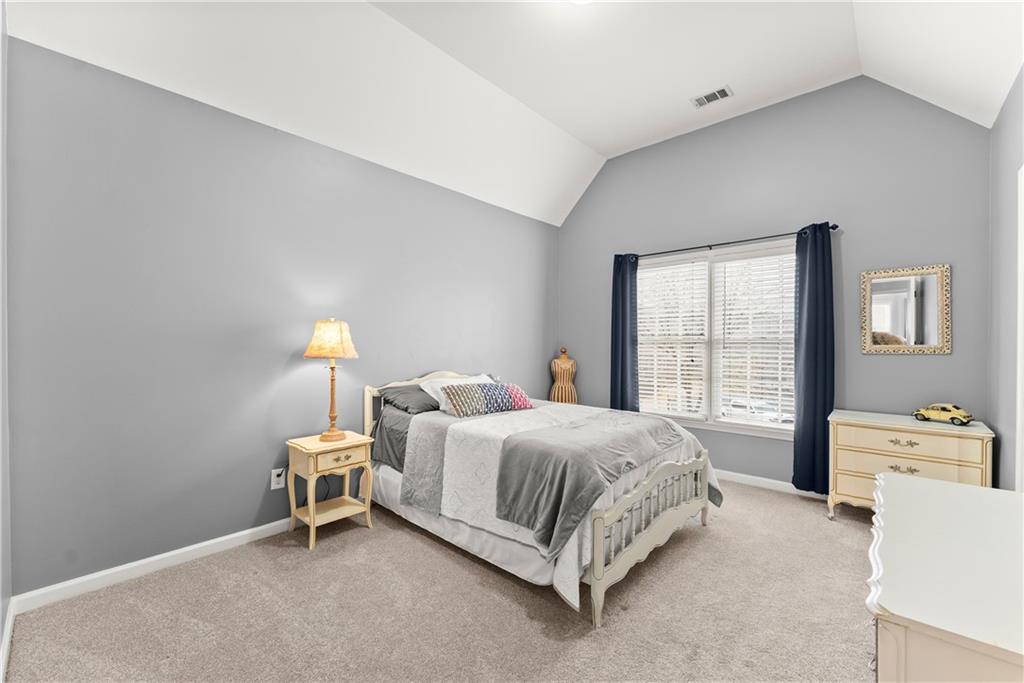 1070 Coleridge Way Suwanee, GA 30024 - Photo 39 of 76 a bedroom with a bed a table and painting on the wall