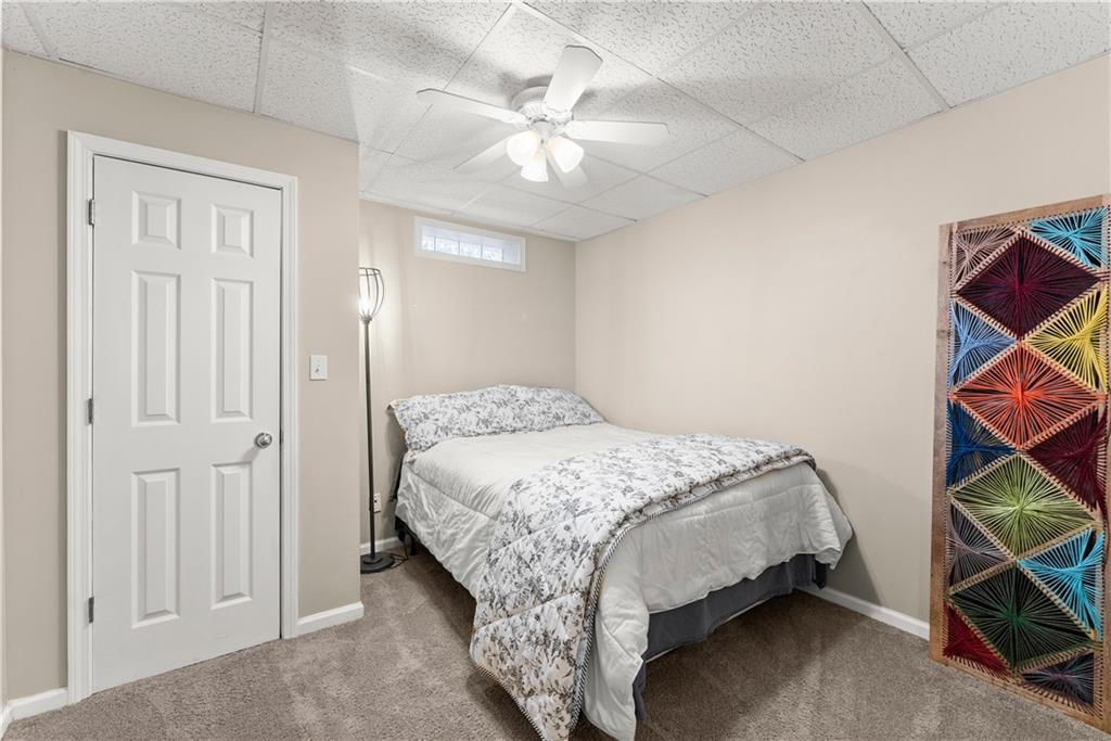 1070 Coleridge Way Suwanee, GA 30024 - Photo 54 of 76 a bedroom with a bed and a chandelier