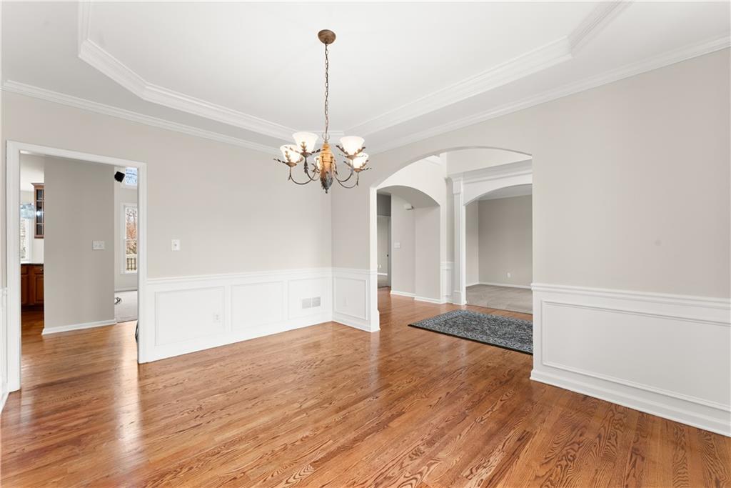 1070 Coleridge Way Suwanee, GA 30024 - Photo 6 of 76 a view of a room with wooden floor chandelier and a kitchen