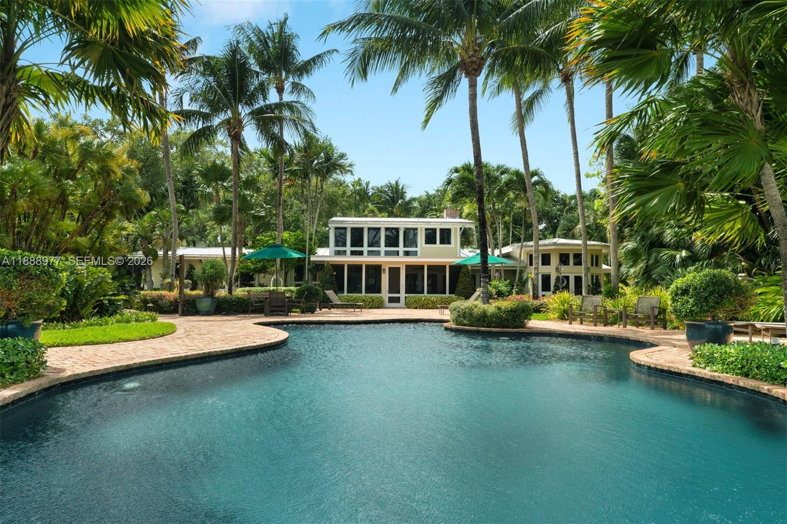 8845 School House Road Coral Gables, FL 33156 - Photo 2 of 23 a view of a swimming pool with a table and chairs