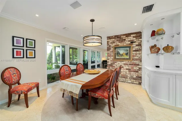 a dining room filled chandelier and wooden floor