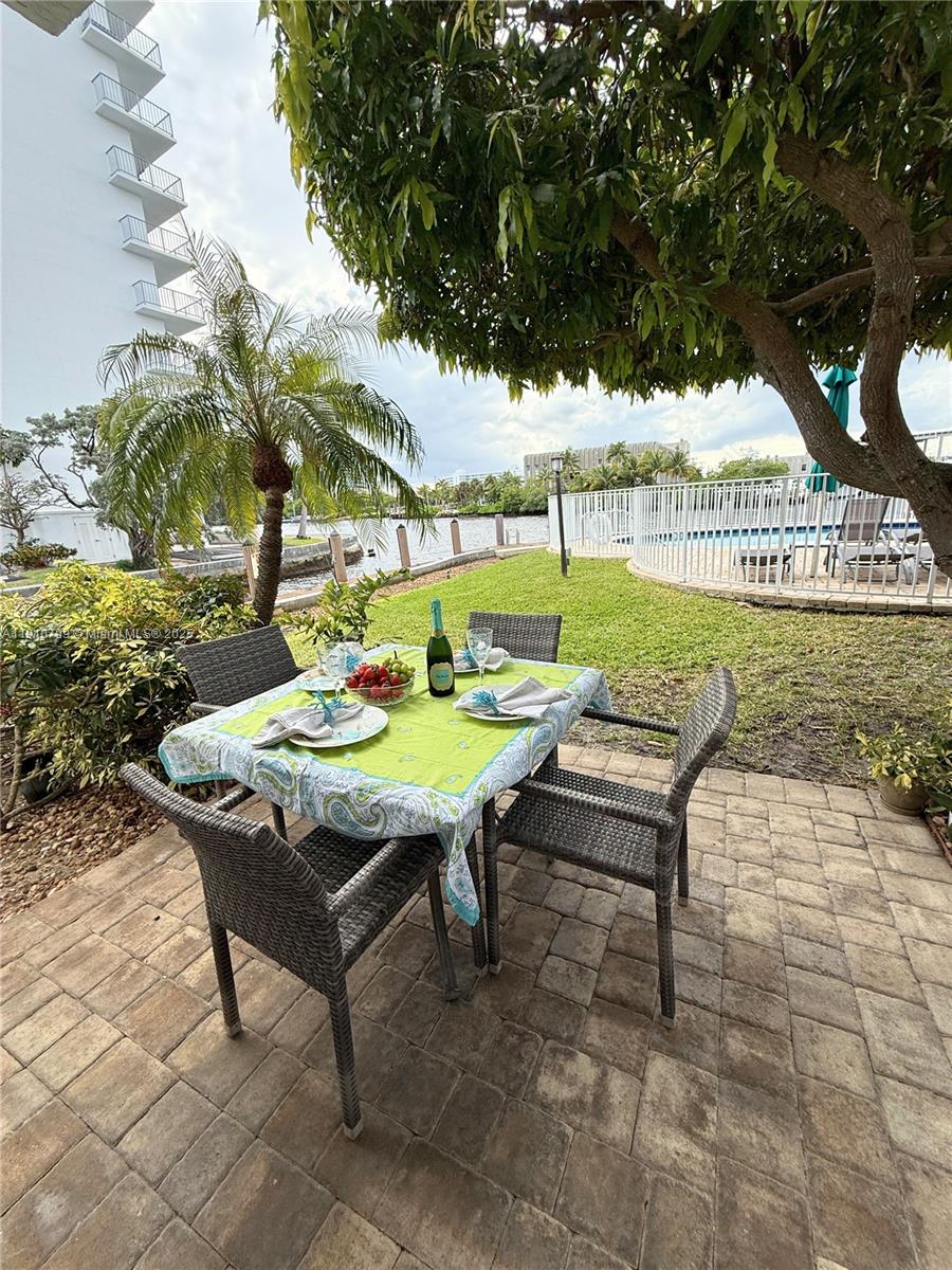 1705 North Riverside Drive, Unit 1 Pompano Beach, FL 33062 - Photo 25 of 36 a backyard of a house with table and chairs