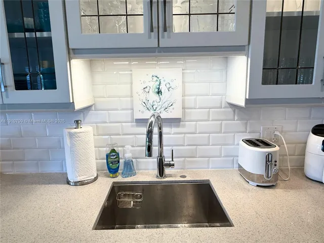 a view of kitchen island with a sink and mirror