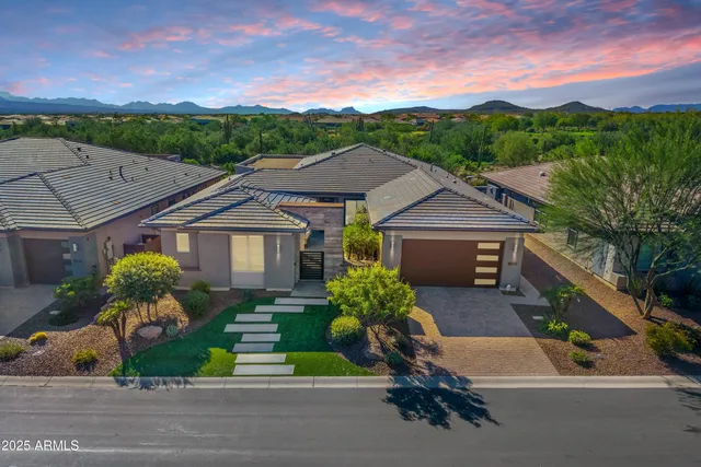 a front view of a house with a yard and potted plants