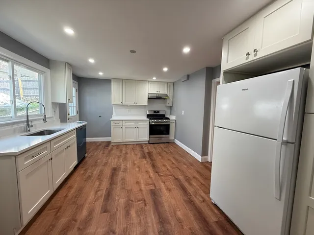 a kitchen with a refrigerator a sink and cabinets