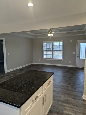 a kitchen with granite countertop a stove and a wooden floors