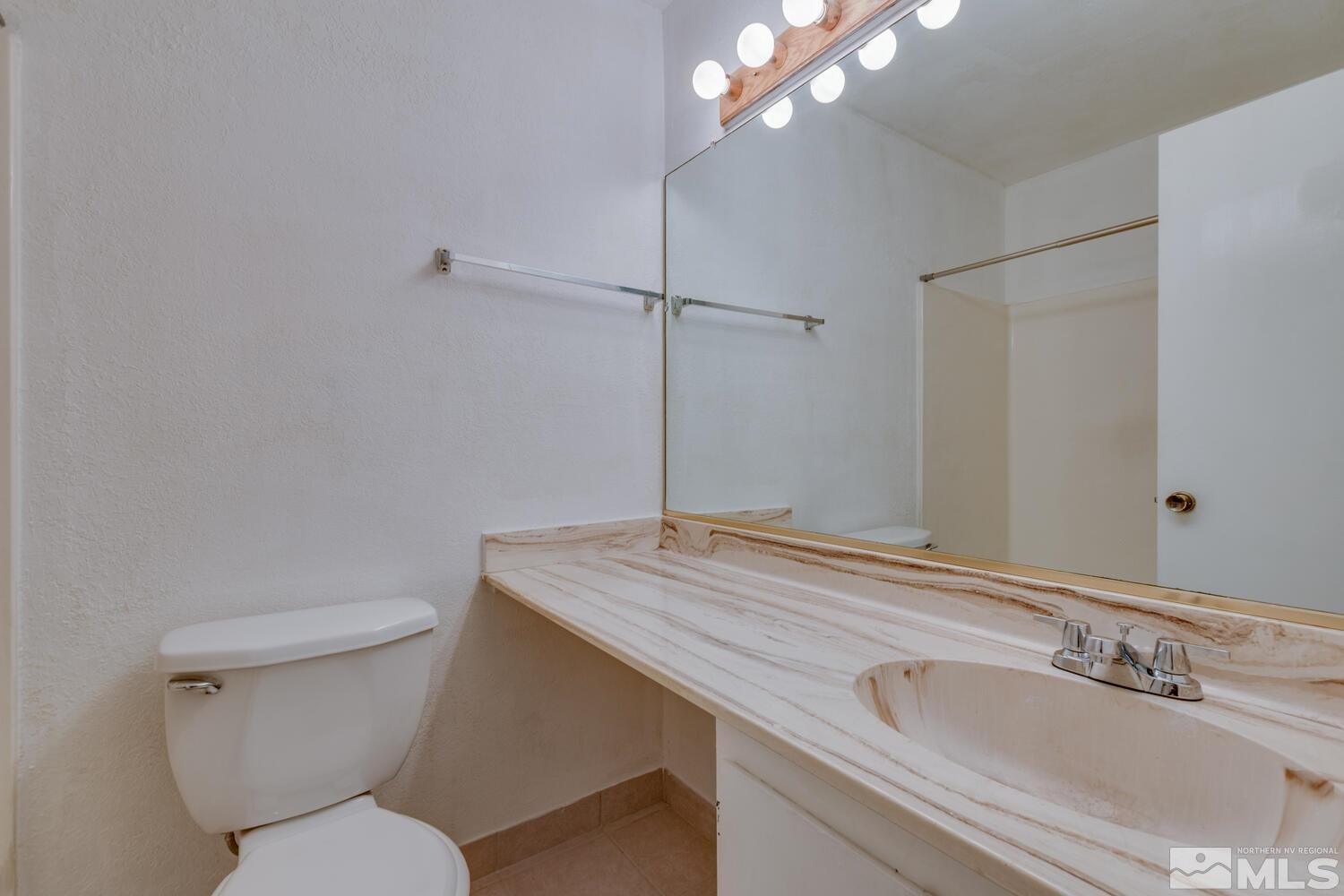 2300 Dickerson Road, Unit 73 Reno, NV 89503 - Photo 14 of 25 a bathroom with a granite countertop sink a toilet and a mirror