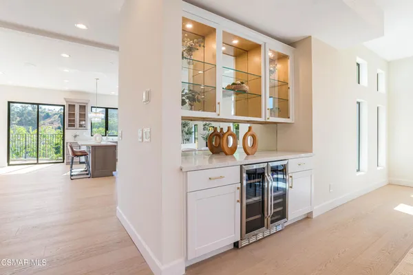 a kitchen with stainless steel appliances granite countertop a stove top oven a sink dishwasher a dining table and chairs with wooden floor