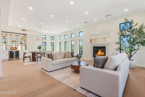 a living room with fireplace furniture and a large window