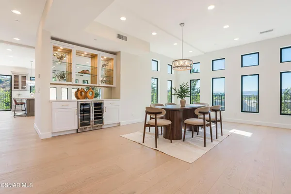a living room with furniture a large window and dining table