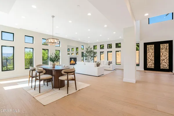 a view of a dining room with furniture large windows and wooden floor