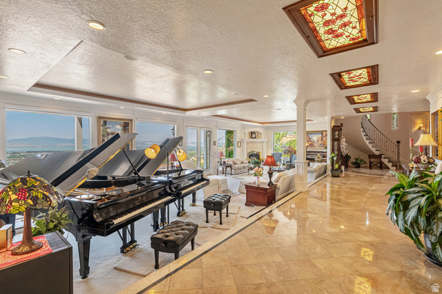 4093 North Imperial Way Provo, UT 84604 - Photo 15 of 96 Expansive interior featuring polished tile flooring, a grand staircase with wrought iron railing, decorative stained-glass ceiling panels, recessed lighting, and a wall of windows showcasing mountain scenery