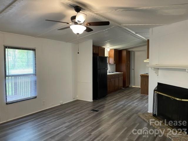 a view of a livingroom with a kitchen and a stove wooden floor