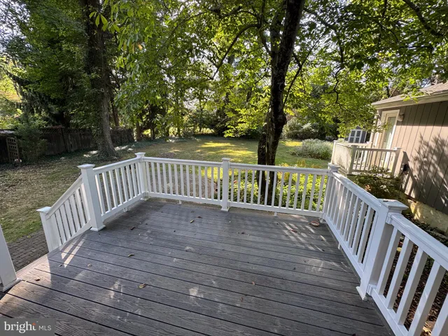 a view of deck with wooden floor and fence with a bench