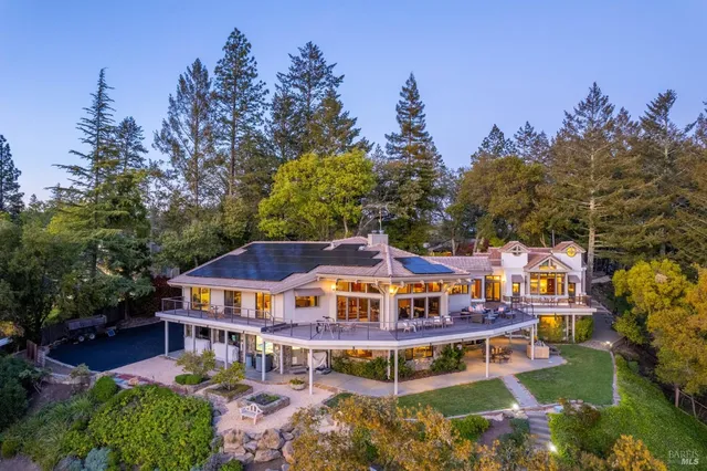 aerial view of a house with swimming pool and lawn chairs under an umbrella