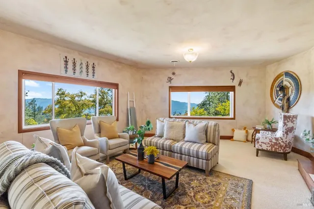 a living room with furniture and floor to ceiling windows