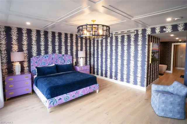 a spacious bedroom with a bed and a chandelier