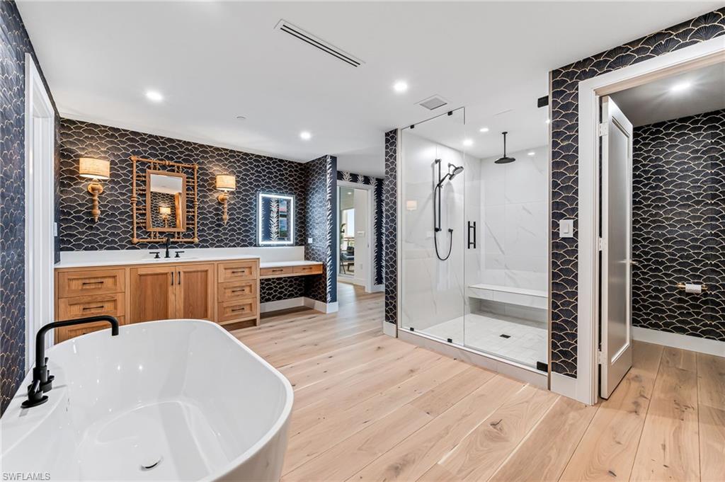 13945 Old Coast Road, Unit 905 Naples, FL 34110 - Photo 13 of 39 a bathroom with a tub a sink a mirror and shower