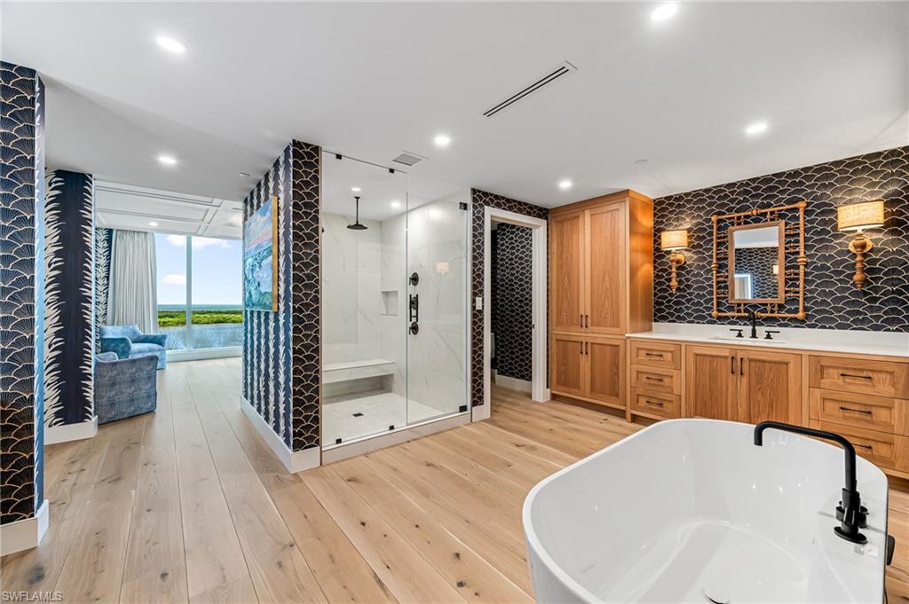 13945 Old Coast Road, Unit 905 Naples, FL 34110 - Photo 14 of 39 a bathroom with a tub sink shower and mirror