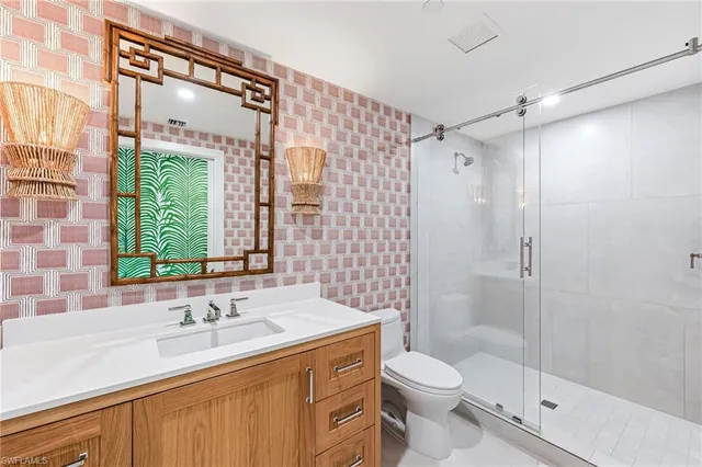 a bathroom with a granite countertop sink toilet and shower