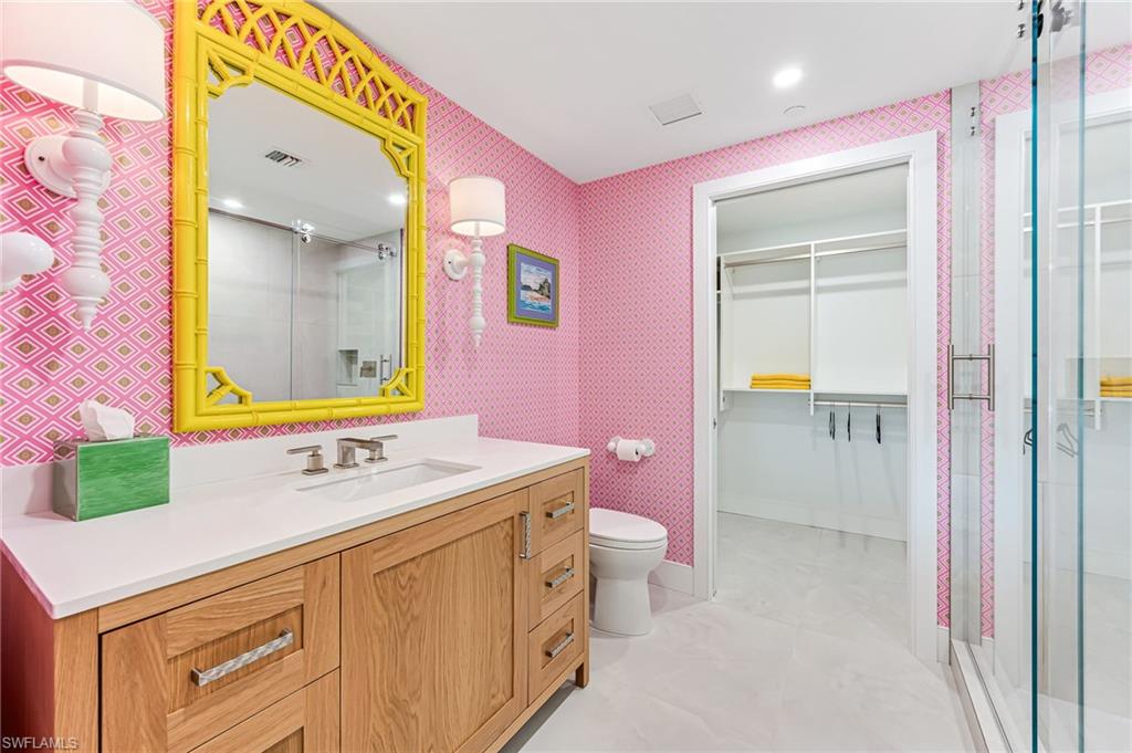 13945 Old Coast Road, Unit 905 Naples, FL 34110 - Photo 21 of 39 a bathroom with a sink mirror and a bath tub