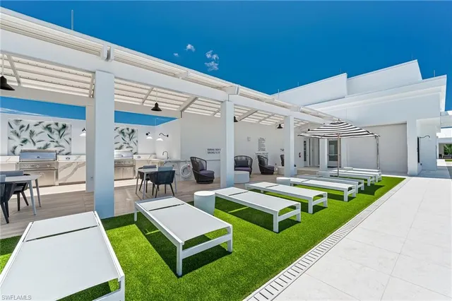 a view of a backyard with swimming pool and sitting area