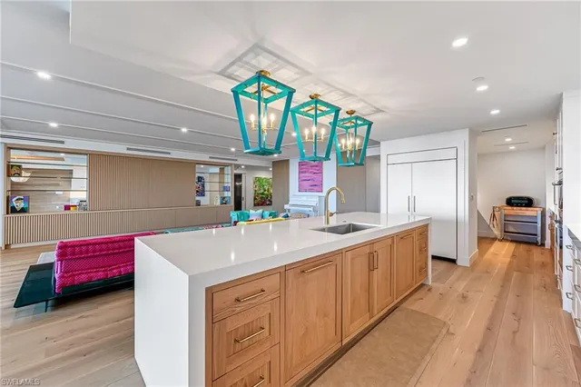 a large kitchen with stainless steel appliances a large counter top a stove and a sink