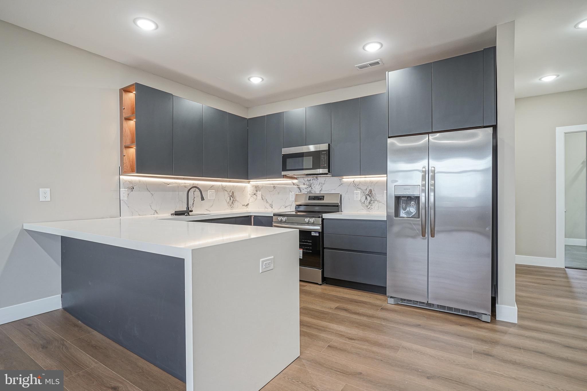 4432-00 Wingate Street, Unit 102 Philadelphia, PA 19136 - Photo 6 of 19 a kitchen with kitchen island a counter top space cabinets and stainless steel appliances