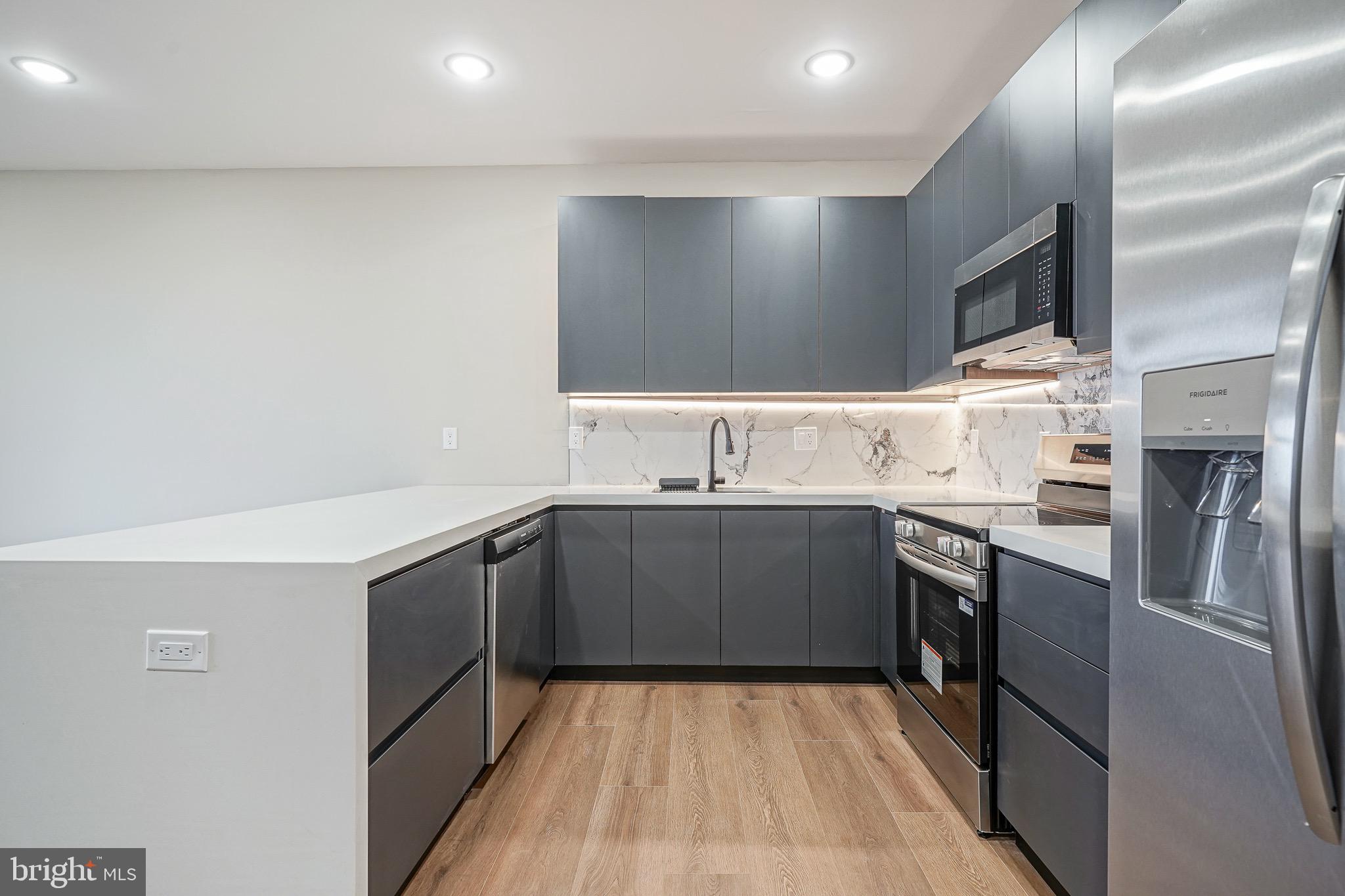 4432-00 Wingate Street, Unit 102 Philadelphia, PA 19136 - Photo 7 of 19 a kitchen with a sink cabinets and stainless steel appliances