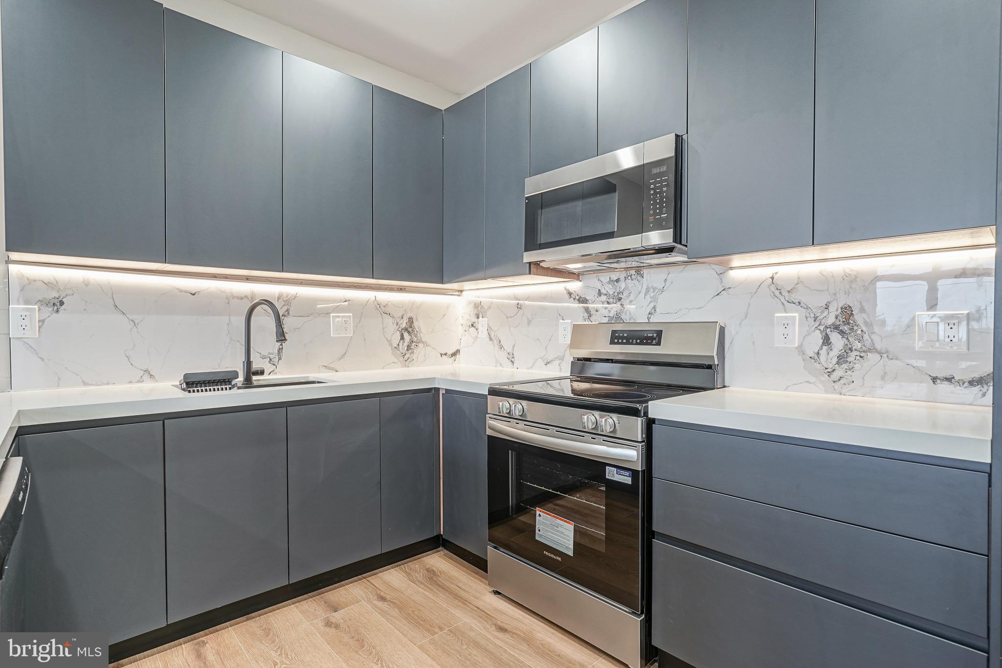 4432-00 Wingate Street, Unit 102 Philadelphia, PA 19136 - Photo 9 of 19 a kitchen with stainless steel appliances a stove sink and microwave