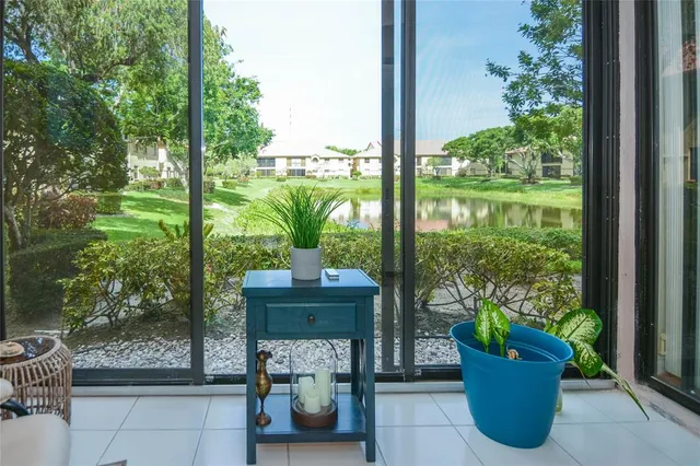 a view of a porch with chairs and potted plants