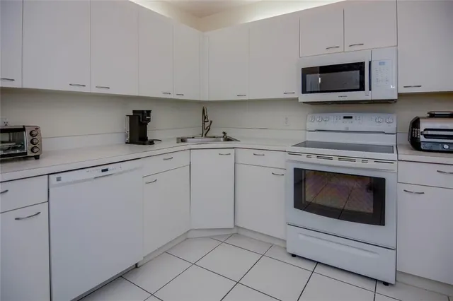 a kitchen with cabinets stainless steel appliances and sink