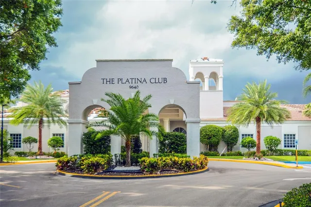 a front view of multi story residential apartment building with yard and sign board