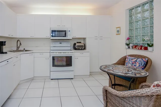 a living room with furniture a flat screen tv and kitchen view