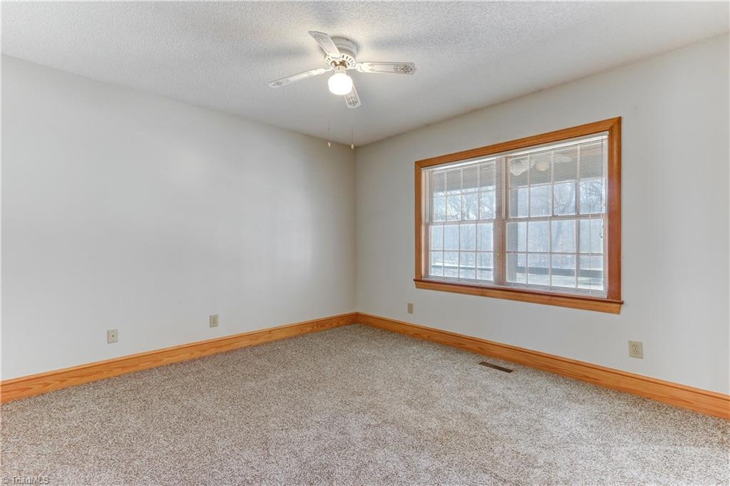 761 Hudson Road Summerfield, NC 27358 - Photo 16 of 28 Bedroom 3 has wall to wall carpeting and ceiling fan with light fixture.