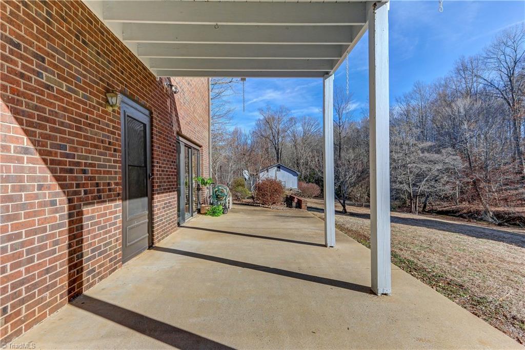 761 Hudson Road Summerfield, NC 27358 - Photo 22 of 28 Lower level patio faces Troublesome Creek. Doors lead into Spa Room.