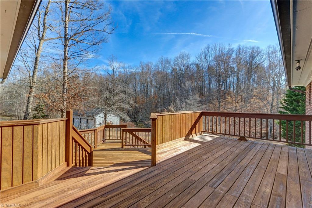 761 Hudson Road Summerfield, NC 27358 - Photo 23 of 28 The Deck off the main level Great Room. Views are toward Troublesome Creek. Building in background is the 3-car detached garage.