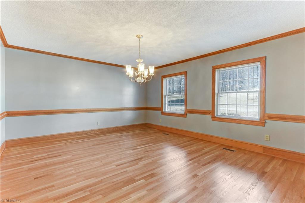 761 Hudson Road Summerfield, NC 27358 - Photo 6 of 28 Large Dining Room with central chandelier, chair and crown moldings. Hardwood flooring continues.