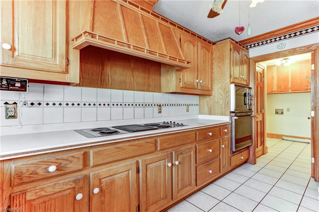 761 Hudson Road Summerfield, NC 27358 - Photo 8 of 28 There is plenty of counter space in this kitchen with the large island and prep space on either side of the cook top. Cook top is 4-Burner with center grill. Commercial exhaust vents outside through roof. Built in oven and Microwave.